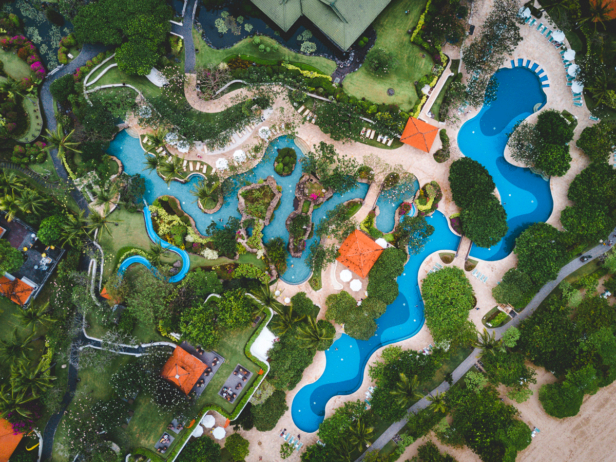 Grand parc aquatique avec bassins turquoise et ambiance tropicale